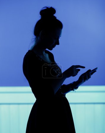 Silhouette  of woman playing the cell phone