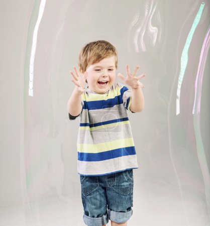 Little cute kid playing a soap bubbles