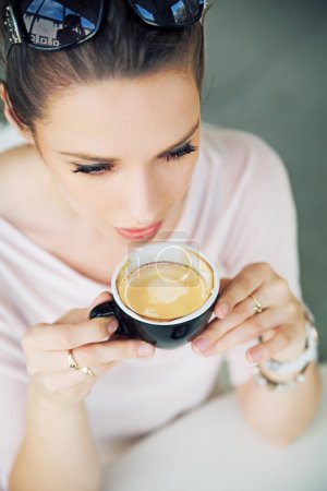 Attractive brunette lady taking a gulp of coffee