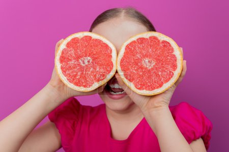 Grapefruit - a young girl has fun with healthy fruits
