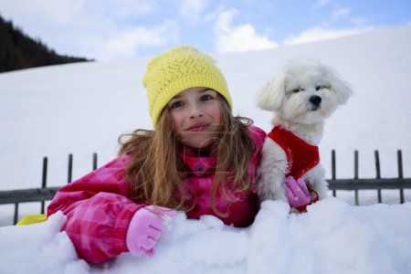 Winter, child, snow - young girl with dog enjoying winter