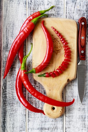 Fresh chili peppers on wooden board
