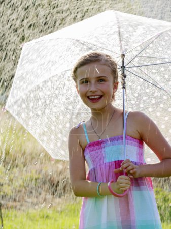 	Summer rain - happy girl with an umbrella in the rain