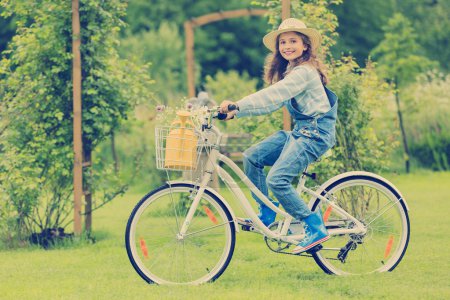 Spring cycling - girl with flowers riding a bike