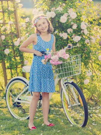 Summer Cycling -  girl with bicycle in summer garden