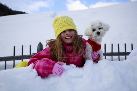 Winter, child, snow - young girl with dog enjoying winter