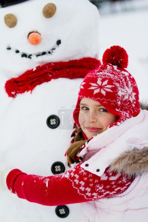 Winter, snowman - lovely girl has a fun in snow