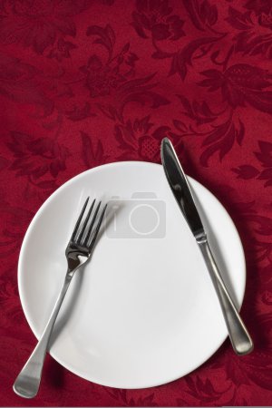 Place Setting on Red Brocade Tablecloth