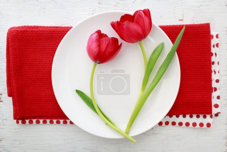 Red tulips on white plate