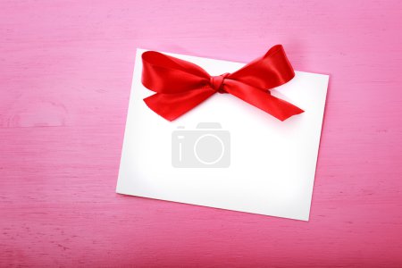 Blank message card on pink wooden board