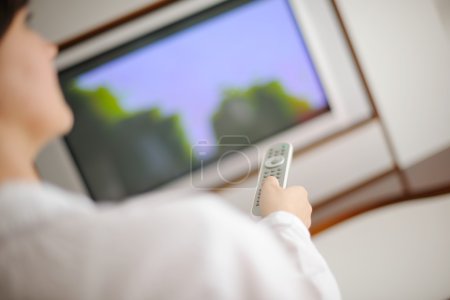 young woman watching tv at home
