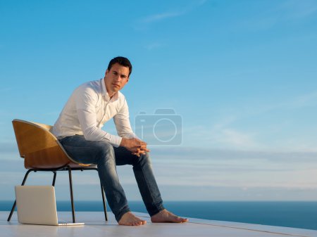 relaxed young man at home on balcony