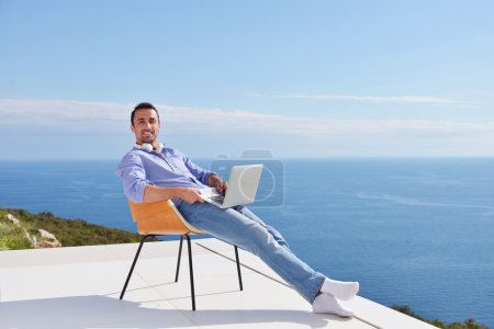 Man on balcony with computer