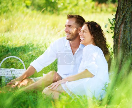 Young Couple Having Picnic in a Park. Happy Family Outdoor