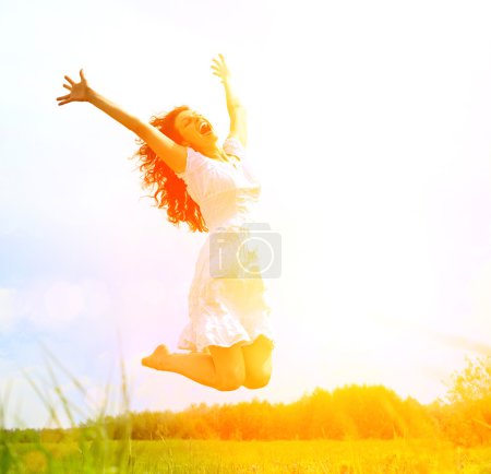 Happy Young Woman Jumping over blue sky. Beauty Girl Having Fun