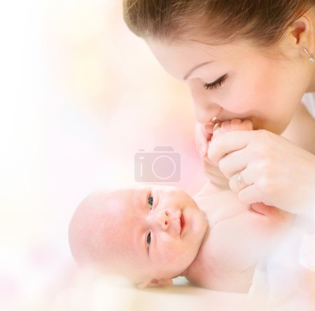Newborn Baby. Happy Mother and Baby kissing and hugging