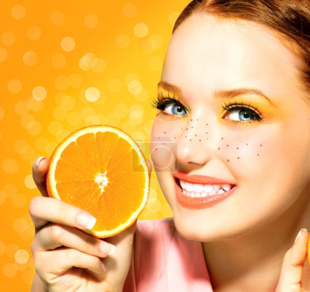 Beauty model girl with juicy oranges. Freckles