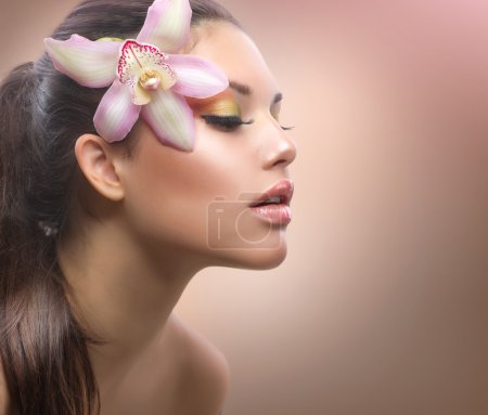 Beauty Portrait. Beautiful Stylish Girl with Orchid Flower