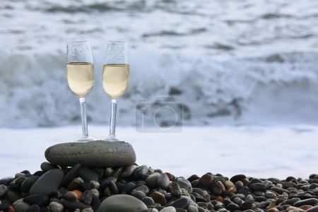 Two glasses of wine on stony beach