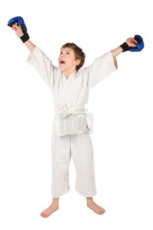 Little boxer boy in white dress and blue boxing gloves hands up