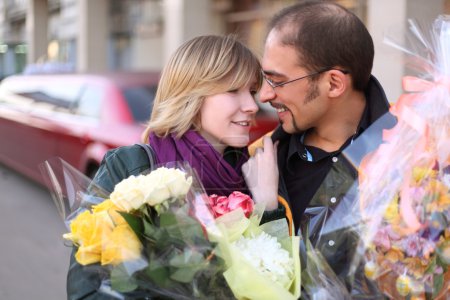 Outdoor portrait of man in glasses and beauty blond girl with fl