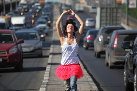 Girl in pink skirt goes on highway middle