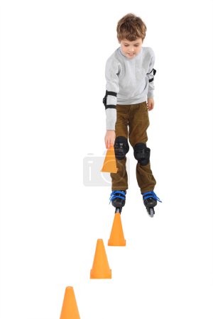 Little boy with cone in hand rollerblading near orange cones loo