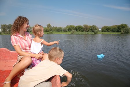 Mother with the children in the boat and the toy ship