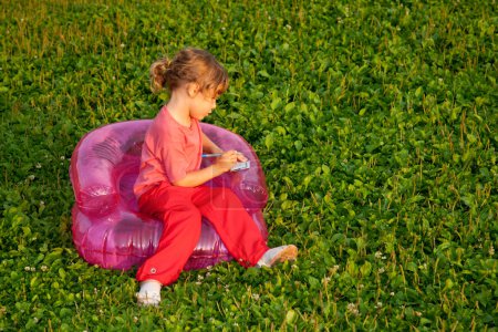 Young writing girl sits in inflatable armchair
