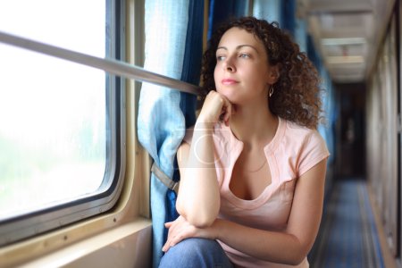 Young woman looks in train window