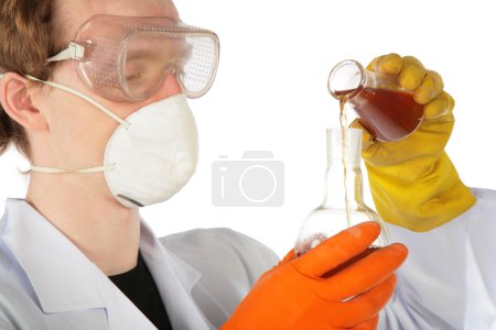 View on scientist in respirator and rubber gloves pours brown l