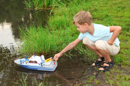 Boy sends toy ship in floating