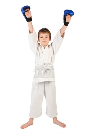 Little boxer boy in white dress and blue boxing gloves hands up