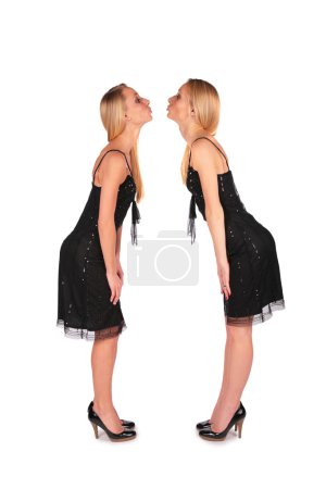 Twin girls stands face-to-face