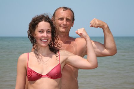 Father and daughter show bicepses