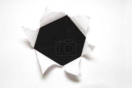 The sheet of paper with the hole against the black background