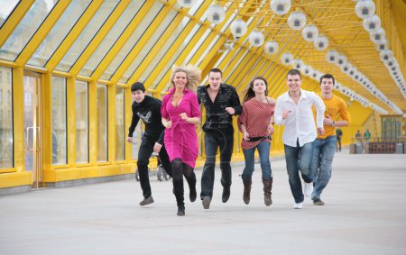 Group of friends runs on yellow footbridge