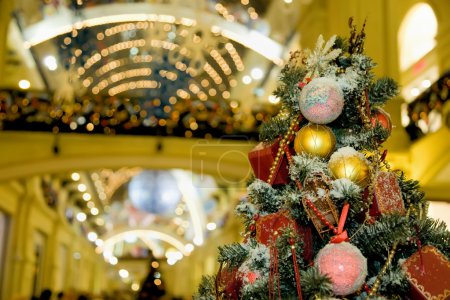 Fur-tree densely covered by Christmas ornaments in shopping cent