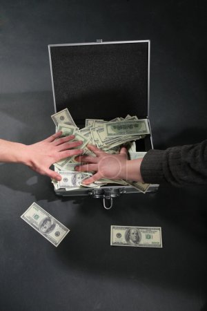Two hands and suitcase with dollars