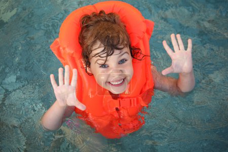 Little girl in inflatable waistcoat in pool