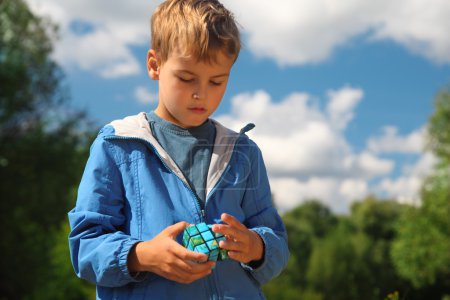 Boy with magic cube outdoor in summer