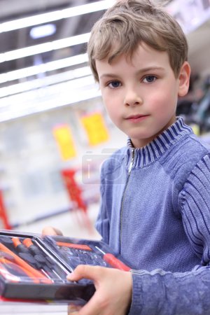 Boy in shop with tool set in hands
