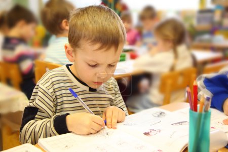Drawing boy in kindergarten