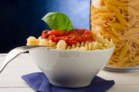 Pasta with tomato sauce on blue background
