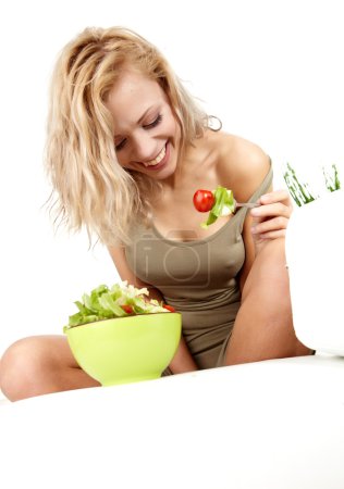 Young happy woman making salad