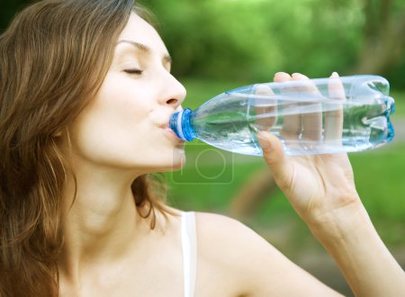Young Healthy Woman Drinks Water From Bottle