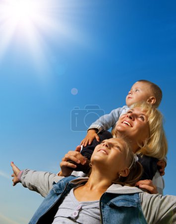 Healthy Family Outdoor. Happy Mother With Kids Over Blue Sky