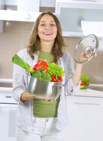 Beautiful Young Woman cooking fresh Vegetables.Dieting Concept.