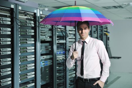 Businessman hold umbrella in server room
