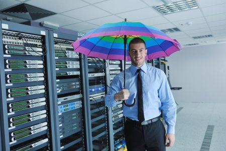 Businessman hold umbrella in server room